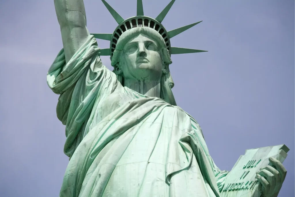 Nahaufnahme der Freiheitsstatue in New York mit erhobener Fackel und Krone vor hellem Himmel