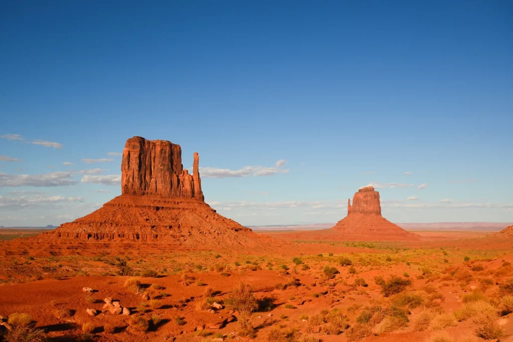 Rote Sandsteinfelsen im Monument Valley in Arizona mit weitem Wüstenpanorama und blauem Himmel