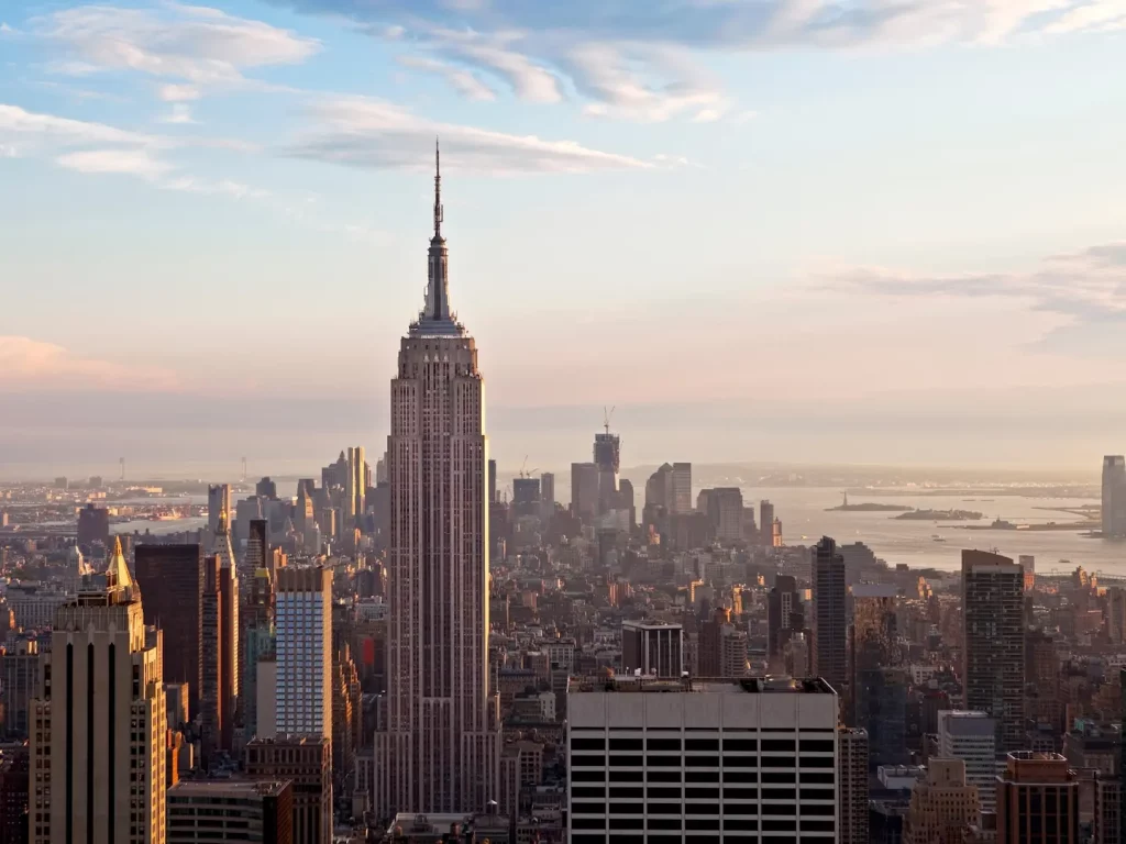 Blick auf das Empire State Building und die Skyline von Manhattan im warmen Abendlicht.